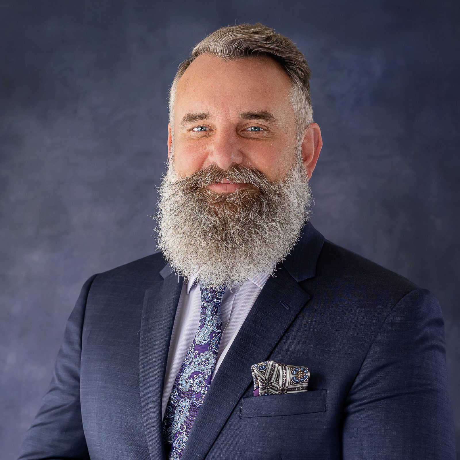 Executive headshot on dark blue backdrop