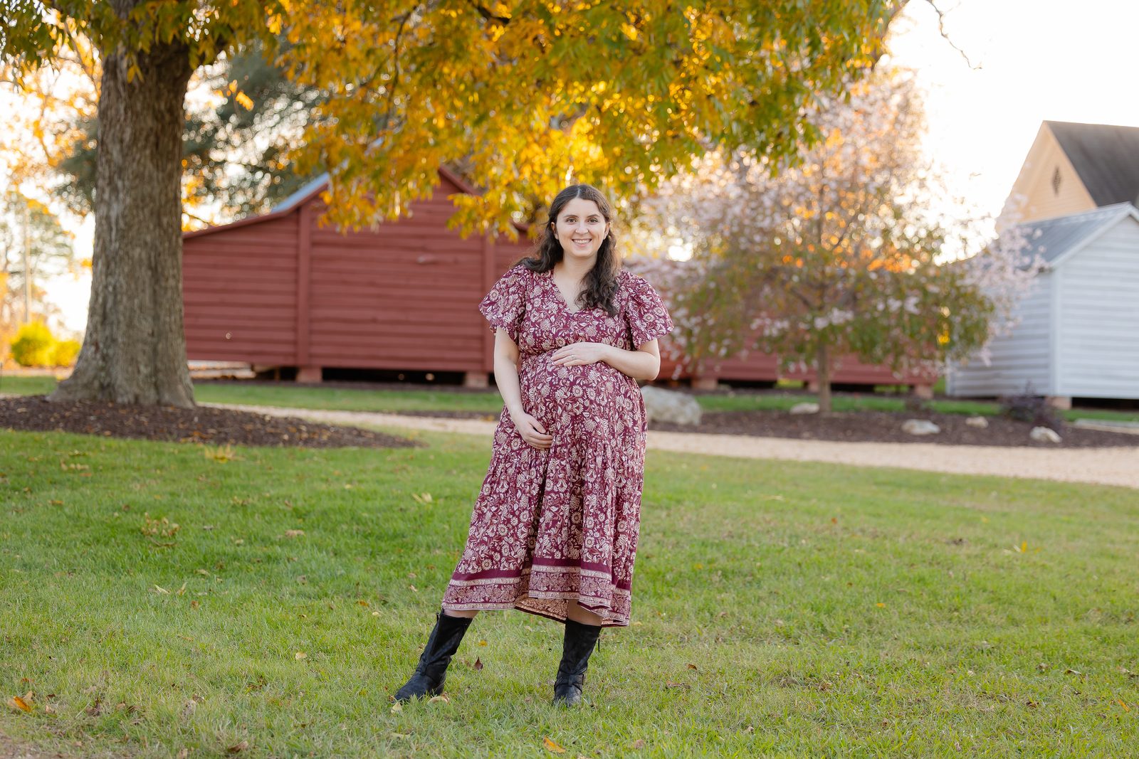 Maternity portrait in burgundy floral dress in autumn