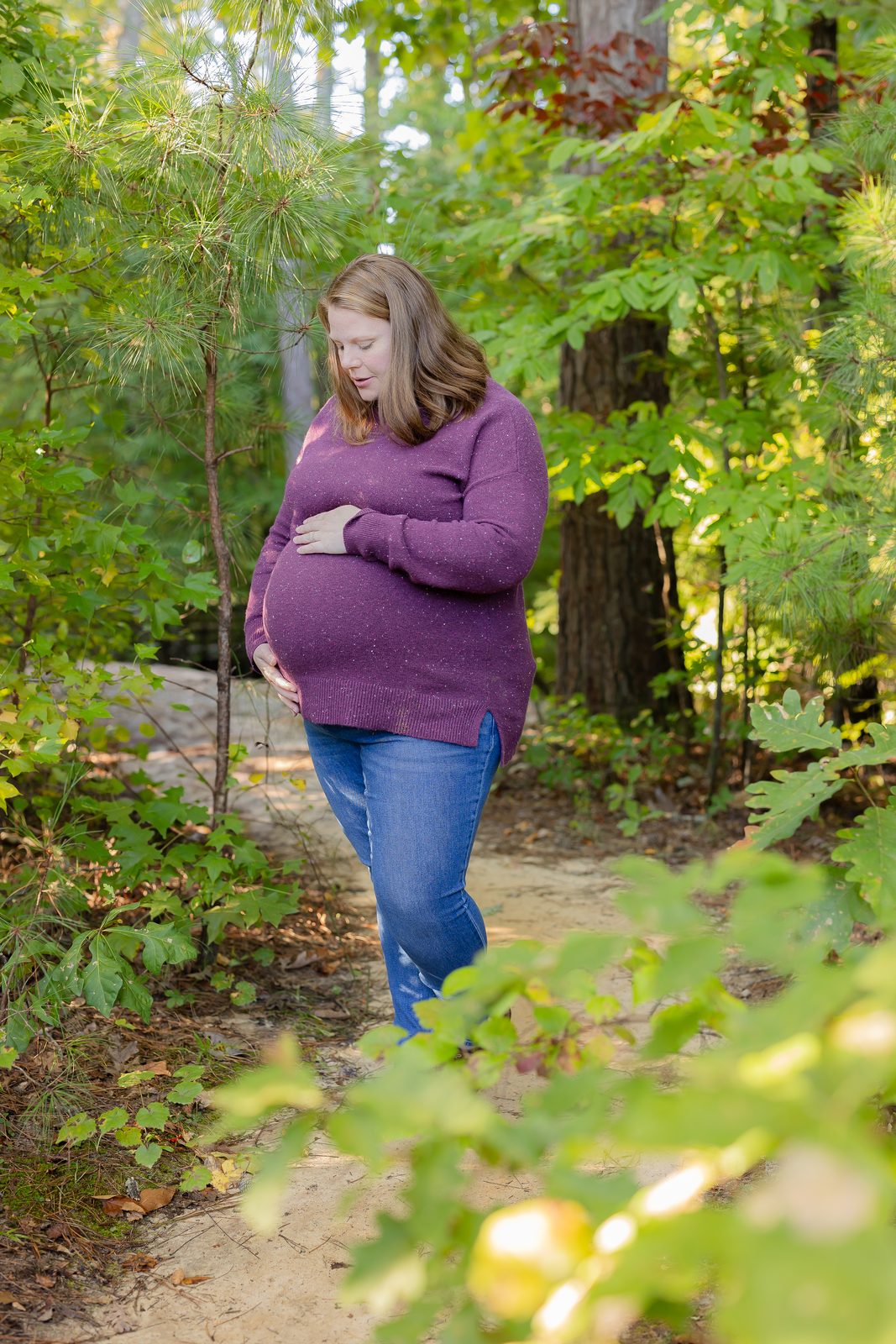 Maternity portrait in purple sweater in woods