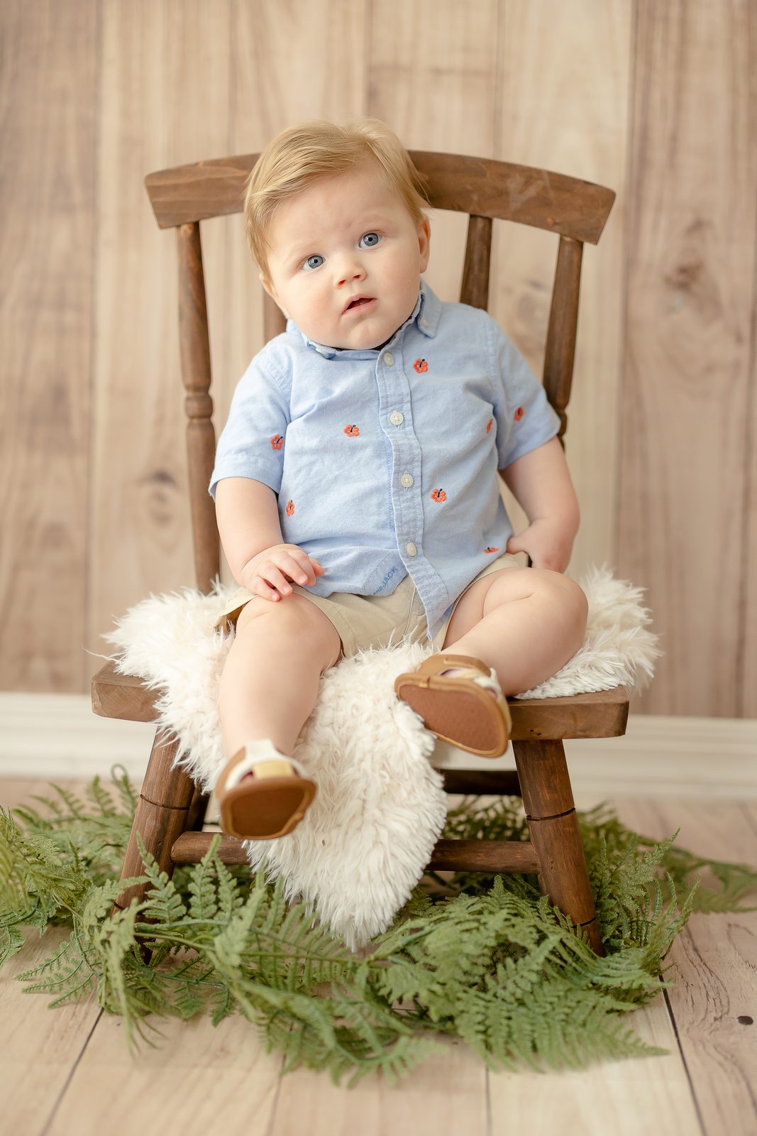 Six-month-old in blue shirt on wooden rocking chair